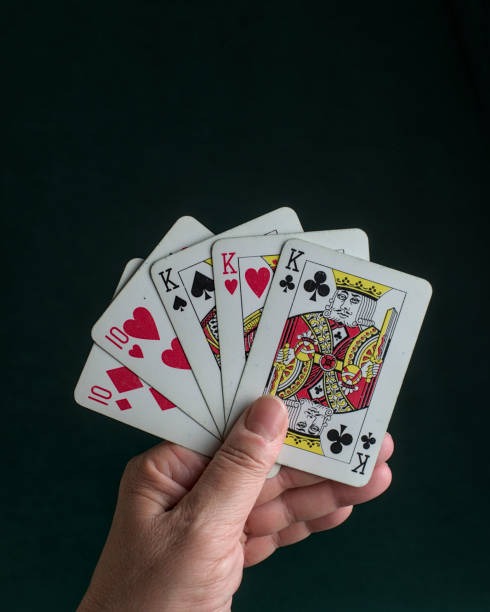 Mobile phone showing Caribbean Stud Poker betting interface with ante and raise buttons